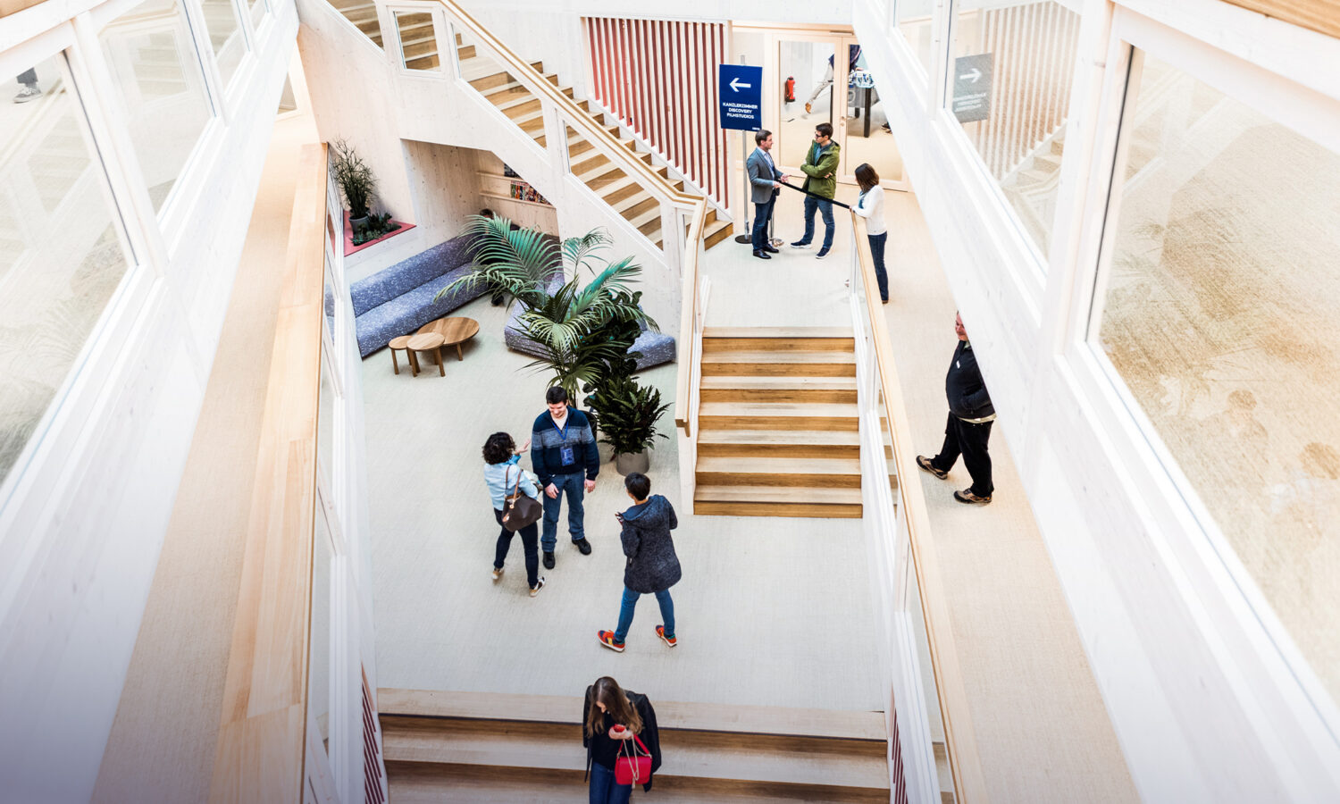 Employees meeting and collaborating in the bright CADFEM Group office atrium.